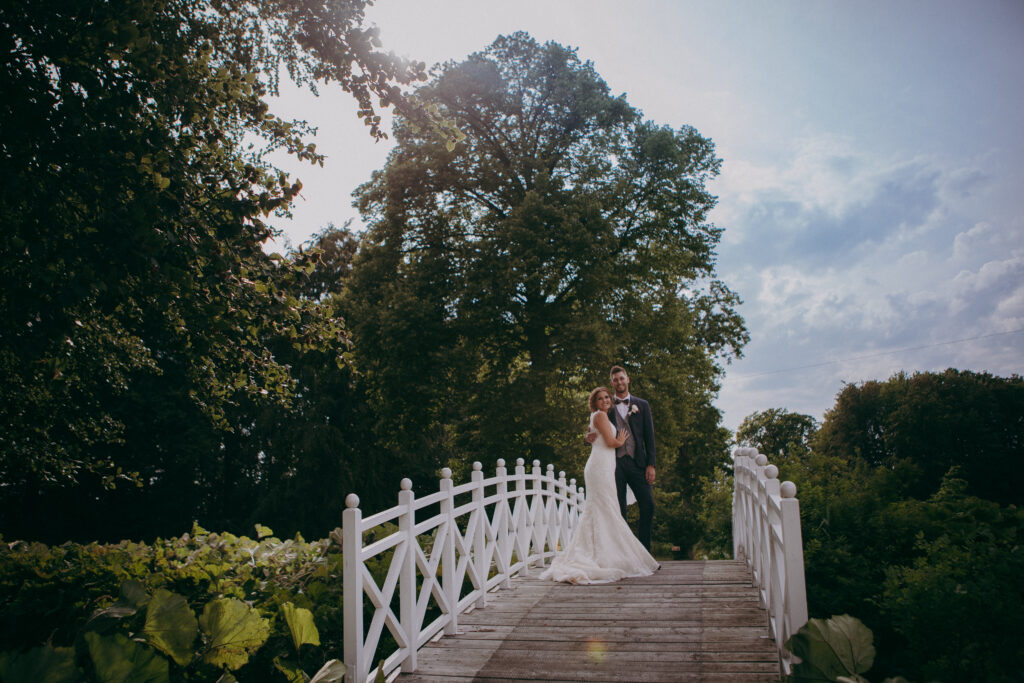 brudepar på hvid bro i solskin