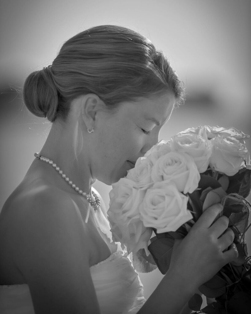 Brud dufter til sin brudebuket af hvide roser