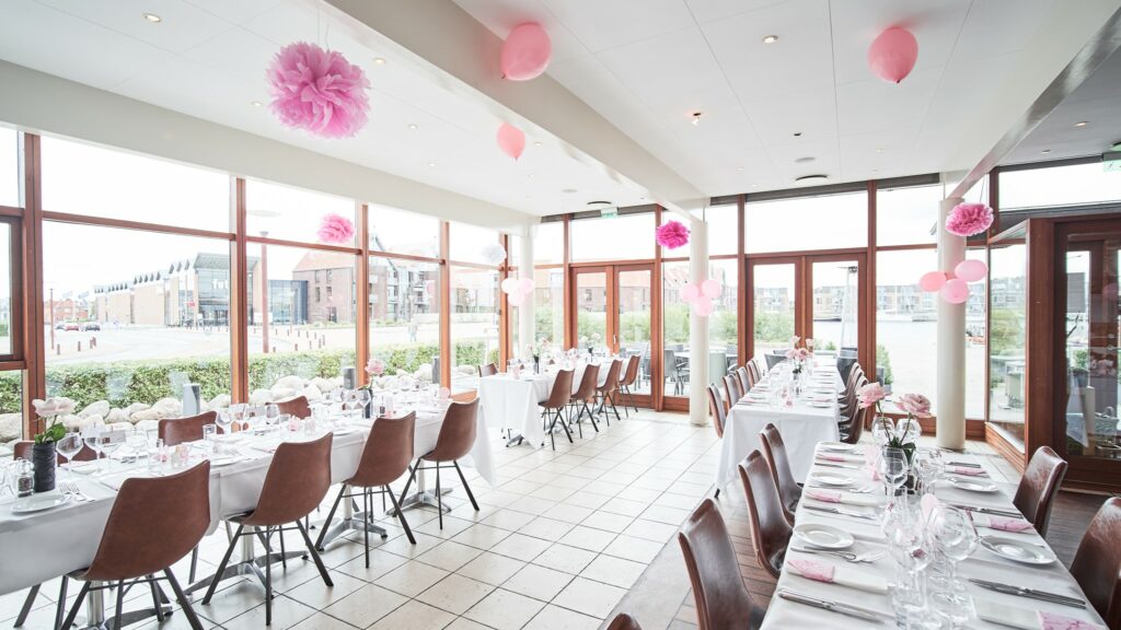 Restaurant Toldboden - Spisesal dekoreret til en konfirmation eller barnedåb med lyserøde dekorationer