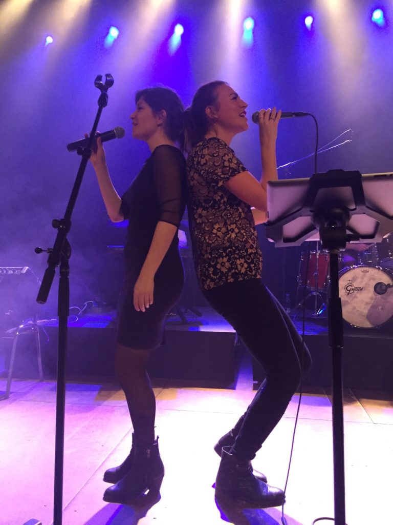 To sangere synge ryg mod ryg på scene