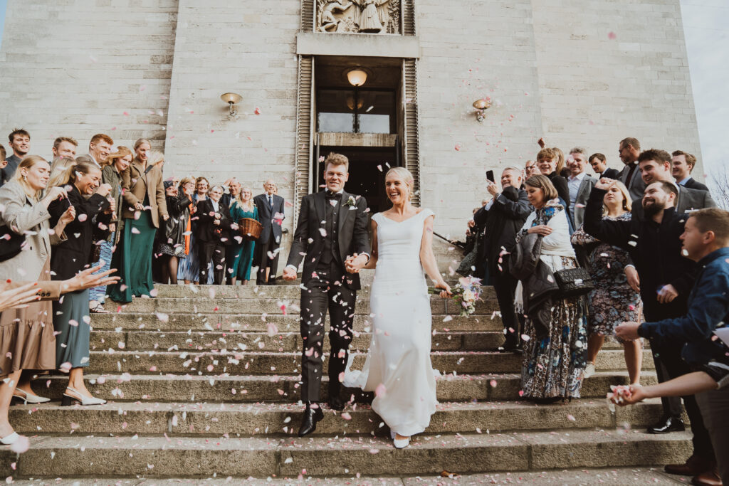 Fotograf Hanna Bursuk - billede af brudepar går ud af kirken med gæster rundt om